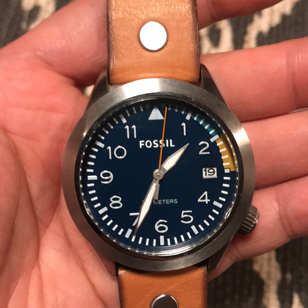 Silver watch with tan leather band.